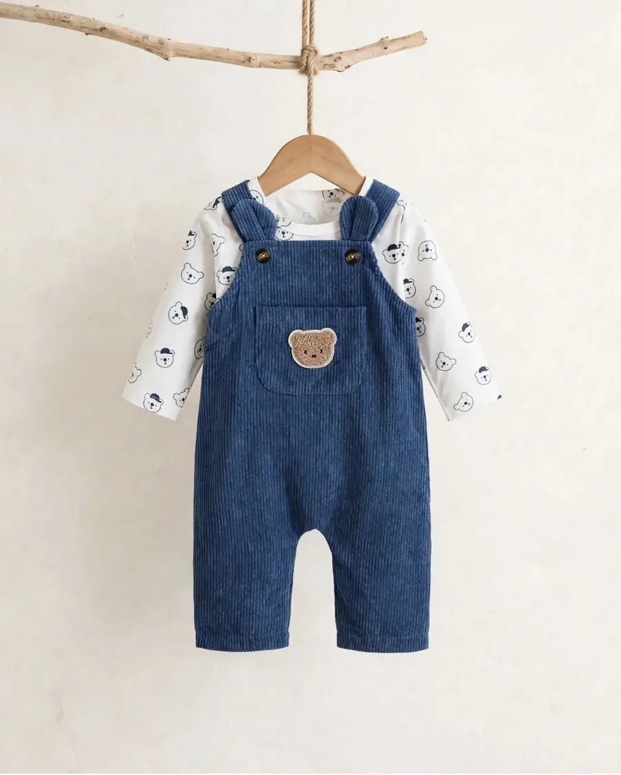 Jardinerito de pana azul con parche de osito, sobre body blanco con estampado de ositos azules